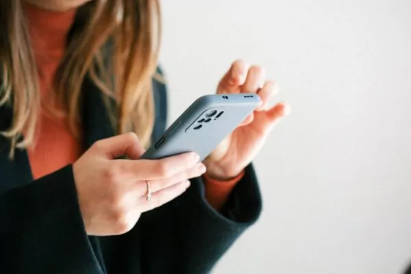 Femme consultant une newsletter sur smartphone, illustrant la communication digitale des collectivités locales pour informer les administrés, promouvoir les événements municipaux et renforcer le lien citoyen.